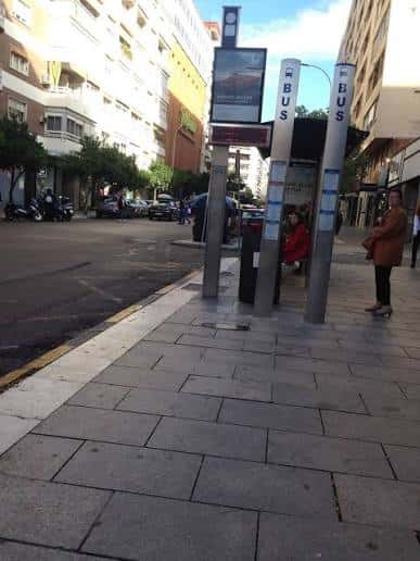 Vista de la parada de autobús en la Avenida Torrequebrada con edificios residenciales al fondo