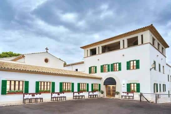 Fachada principal del edificio con patios y bancos listos para eventos