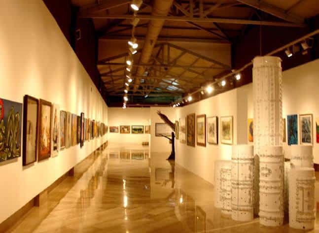 Sala decorada con exposiciones artísticas y elementos escultóricos, mostrando versatilidad del espacio