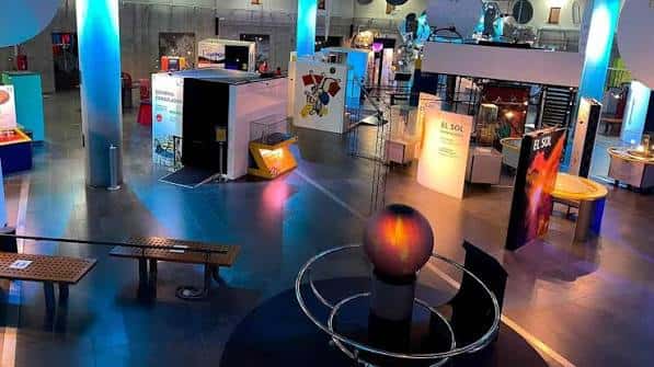 Vista general del interior del museo con exhibiciones interactivas e iluminación ambiental azul