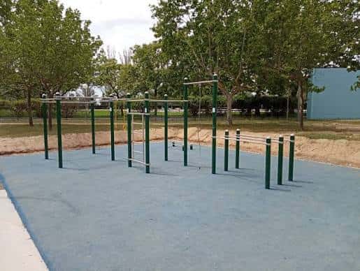 Zona de entrenamiento al aire libre con barras y estructuras verdes