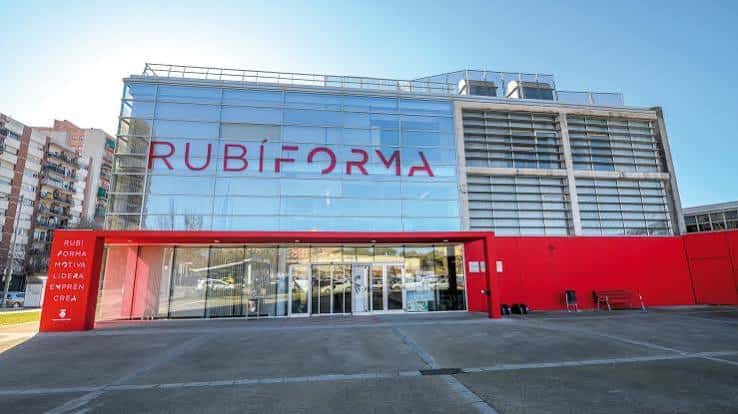 Vista frontal del edificio Rubí Forma con fachada de cristal y detalles en rojo
