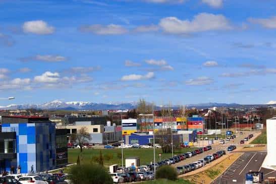Vista panorámica del Parque Tecnológico de León con edificios modernos y montañas nevadas al fondo