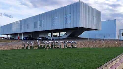 Edificio corporativo con letrero 'mAbxience' en césped verde