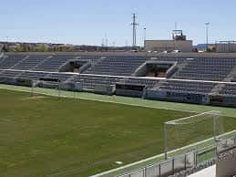 Vista lateral del estadio con las gradas vacías y el campo de fútbol