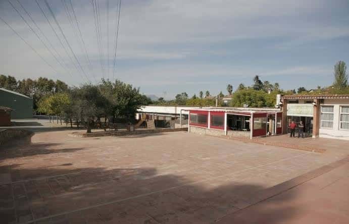 Plaza exterior del complejo cultural con áreas verdes y estructuras modernas