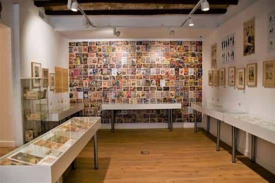 Interior de la sala de exposiciones con murales de cómics