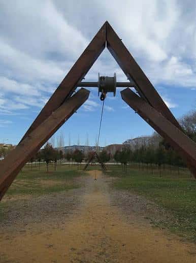 Escultura triangular de madera con carrete central en el Parc de Domeny