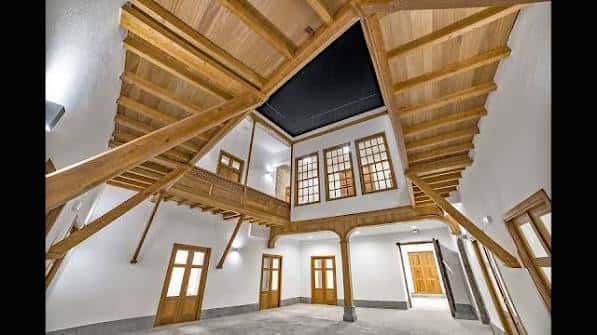 Interior del edificio con estructura de madera y techos altos