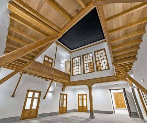 Espacio interior amplio con vigas de madera y ventanas grandes