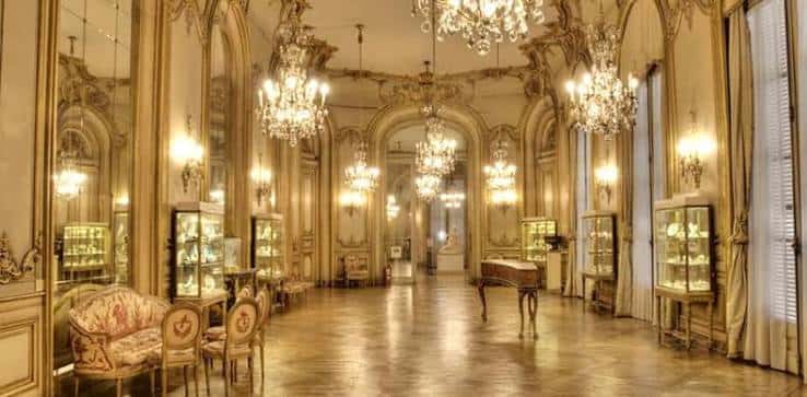 Salón de espejos con lámparas de cristal y mobiliario histórico