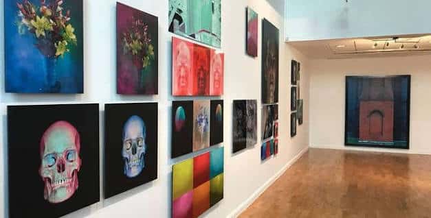 Galería interior del instituto con exposiciones de arte contemporáneo y obras coloridas en las paredes