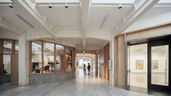Área de recepción y circulación en SOLO CSV con elementos de madera y cristal