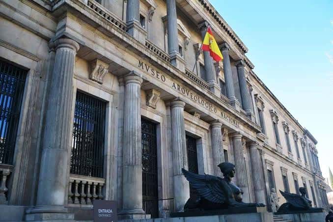 Fachada neoclásica del museo con columnas y estatuas de esfinges