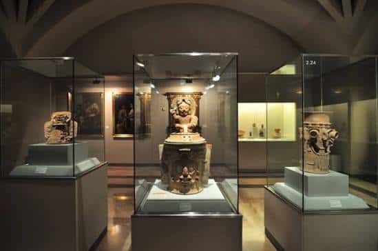 Interior del museo con vitrinas de arte precolombino y esculturas antiguas