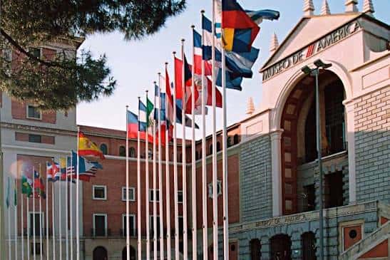 Fachada principal del Museo de América con banderas de países americanos ondeando