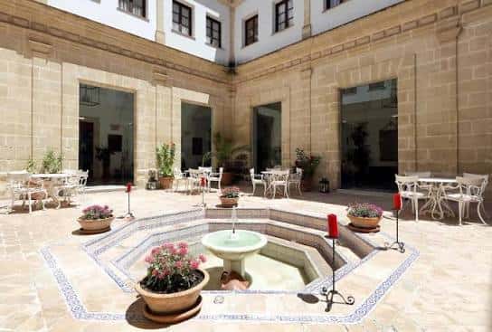 Patio interior con fuente central y mesas para eventos