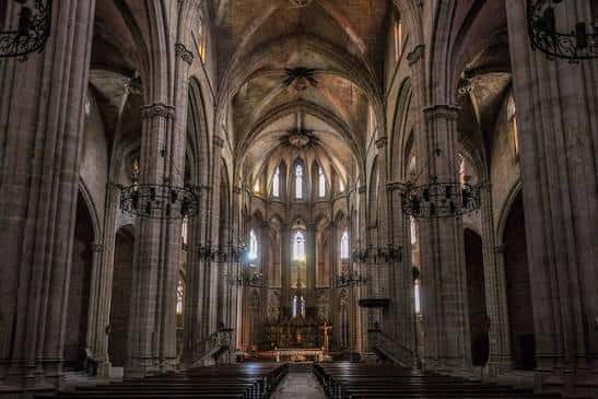 Interior de la nave central de la catedral, mostrando las altas columnas góticas y el altar mayor