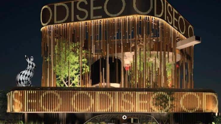 Iluminación nocturna del centro Odiseo, destacando su arquitectura moderna y la escultura de un zorro en la terraza