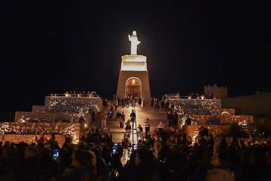 El Cerro de San Cristóbal iluminado por la noche durante una celebración con multitud de personas
