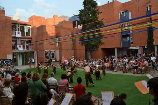 Evento cultural al aire libre en el patio del Centre Cívic Mestral con público y artistas