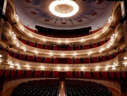 Interior del auditorio del Teatre Fortuny con sus múltiples balcones, butacas rojas y el gran candelabro central