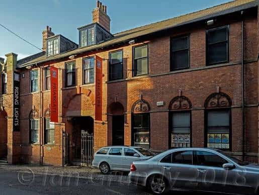 Fachada exterior del Friargate Theatre en York, edificio de ladrillo con letreros rojos y coches aparcados frente a la entrada