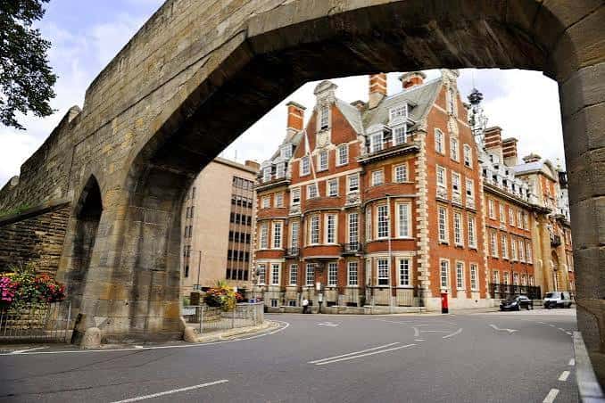 Vista exterior del Hotel The Grand en York, con fachada de ladrillo rojo y arco de piedra