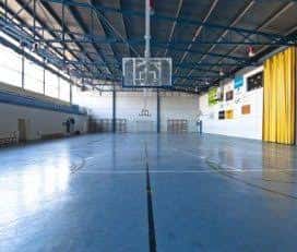 Pabellón deportivo interior con cancha de baloncesto y gradas