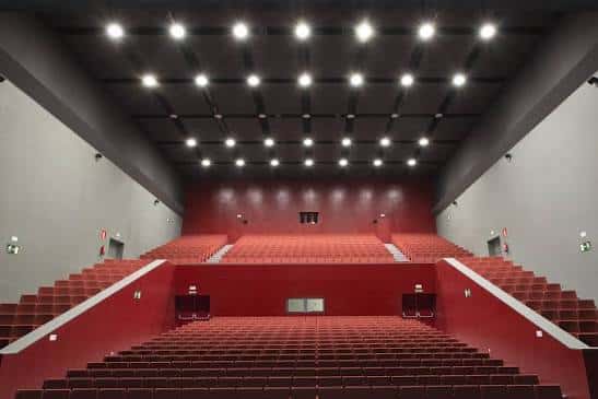 Interior del auditorio con butacas rojas y techo de luces