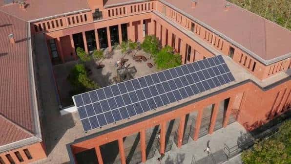 Vista aérea del patio interior del campus con paneles solares y zonas verdes