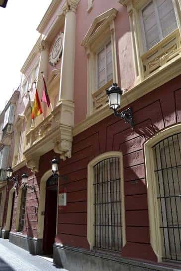 Fachada histórica del Museo de las Cortes con detalles arquitectónicos y banderas