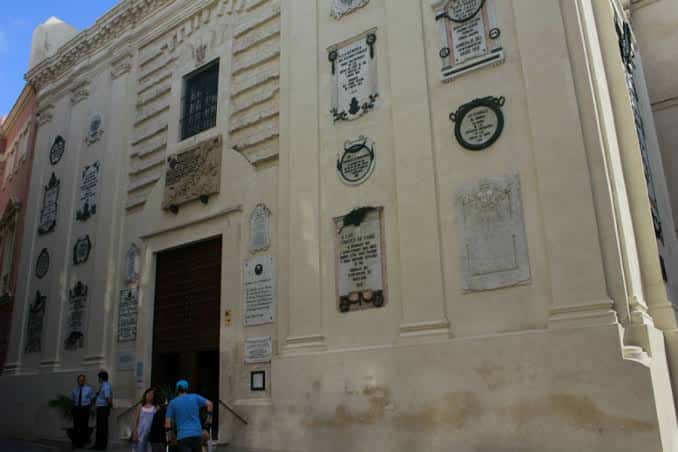 Entrada principal del museo con placas conmemorativas y visitantes