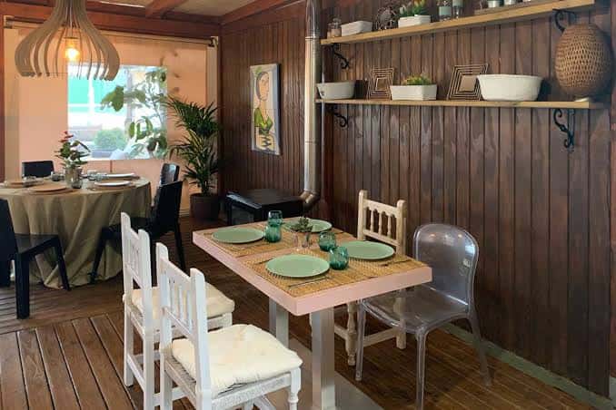 Interior acogedor con mesas dispuestas para cena en ambiente rústico