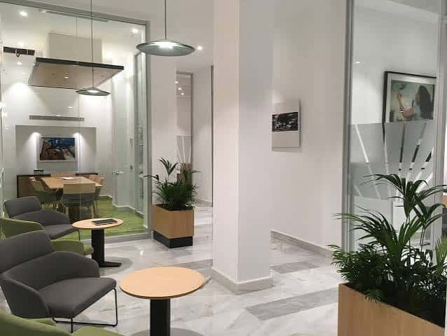 Sala de espera moderna con mobiliario contemporáneo y plantas decorativas