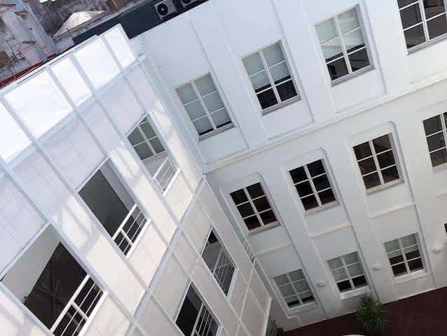 Vista cenital del patio interior con arquitectura blanca y ventanas simétricas