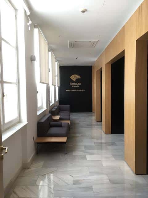 Pasillo principal con suelo de mármol y logo de la Fundación Unicaja al fondo