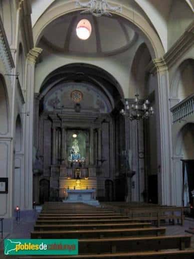 Interior de la nave principal con altar y bancos de madera
