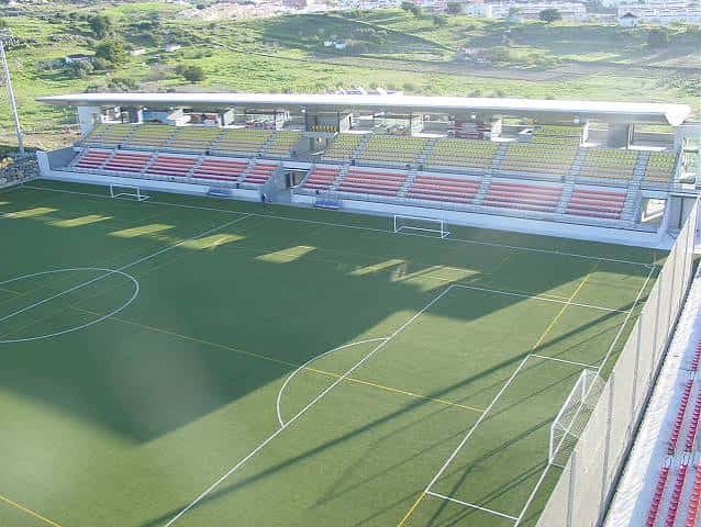 Vista aérea del campo de fútbol con gradas vacías y césped verde