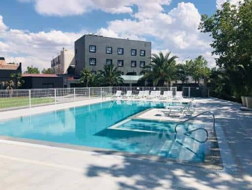 Piscina exterior del hotel con tumbonas y cielo despejado