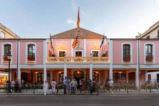 Fachada principal del Teatro Pereyra en Ibiza con iluminación cálida y público en la acera