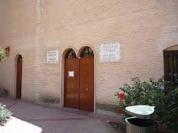 Entrada principal de la biblioteca con fachada de ladrillo y puerta de madera