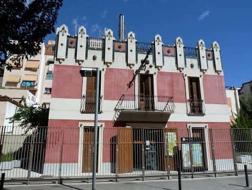 Fachada principal de la Casa dels Cargols con detalles modernistas y cielo azul