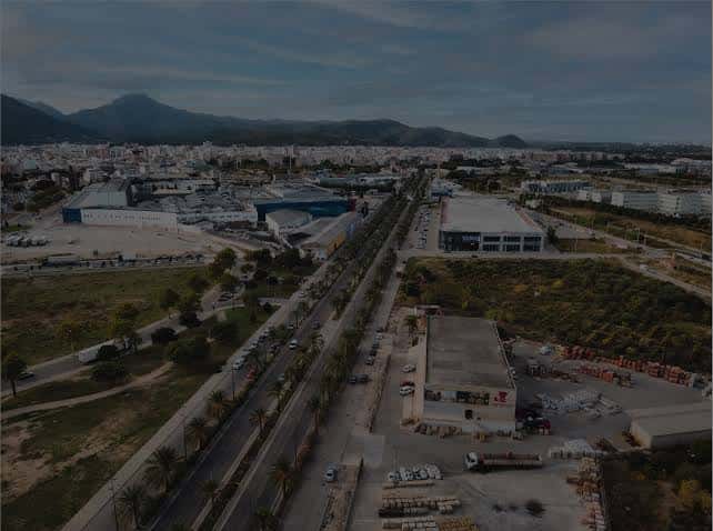 Vista aérea panorámica del Polígono Industrial Benieto con el puerto y montañas al fondo