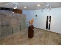 Sala de exposiciones interior con obras de arte y mobiliario minimalista