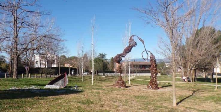 Vista panorámica del parque con esculturas de metal y árboles en un día soleado