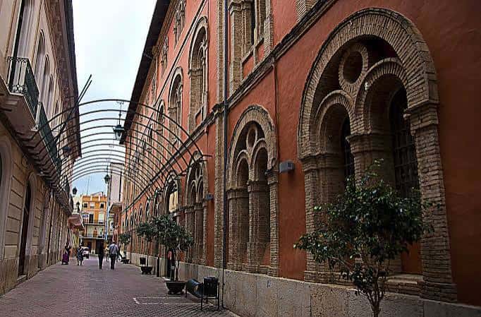 Fachada exterior del edificio con arcos de ladrillo y detalles arquitectónicos
