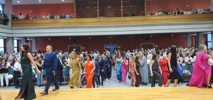 Evento en el auditorio con graduados y público en el balcón