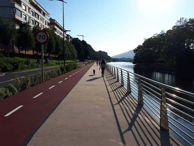 Paseo peatonal y ciclista junto al río con vista a la ciudad