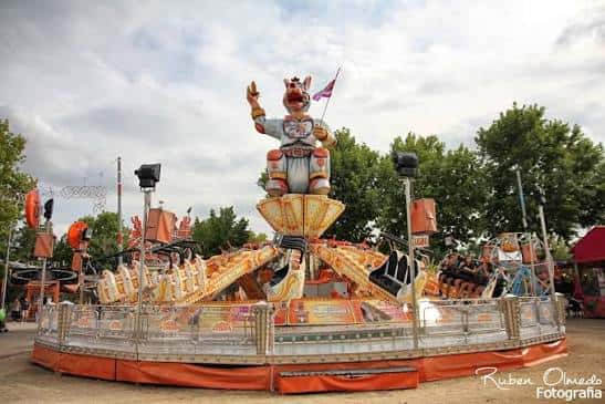 Carrusel temático del Real de la Feria con figura central de cerdo y ambiente festivo